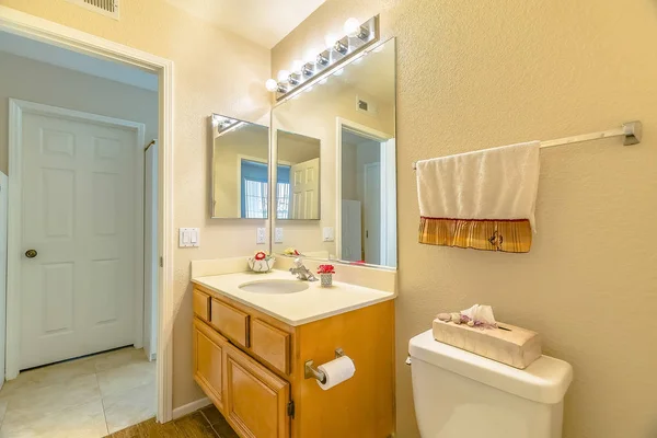 Vanité et toilettes à l'intérieur de la salle de bain d'une maison avec plancher brun — Photo