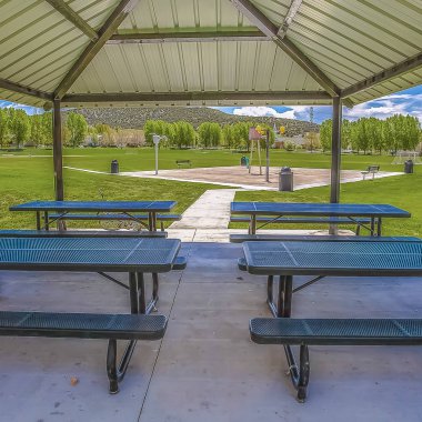 Yemyeşil otlar ve ağaçlarla çevrili bir köşkün içindeki Açık hava yeme alanı