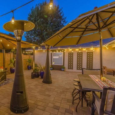 Dize ışıkları ve lamba direkleri ile aydınlatılmış bir evin Kare Taş tuğla veranda