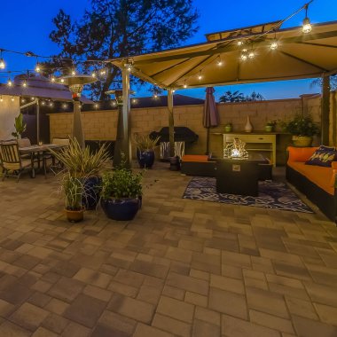 Bir şemsiye altında bir çardak ve yemek alanı altında oturma alanı ile ev Square Patio