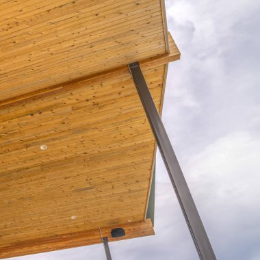 Girişe çıkan merdivenlerin ötesine uzanan çatılı Kare Ev