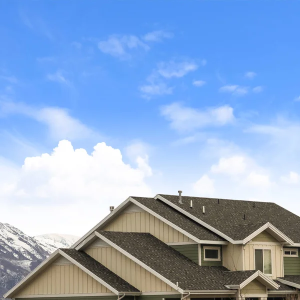 曇り青い空に対して暗いピッチの屋根の眺めを持つ正方形のフレームハウスの外観 — ストック写真