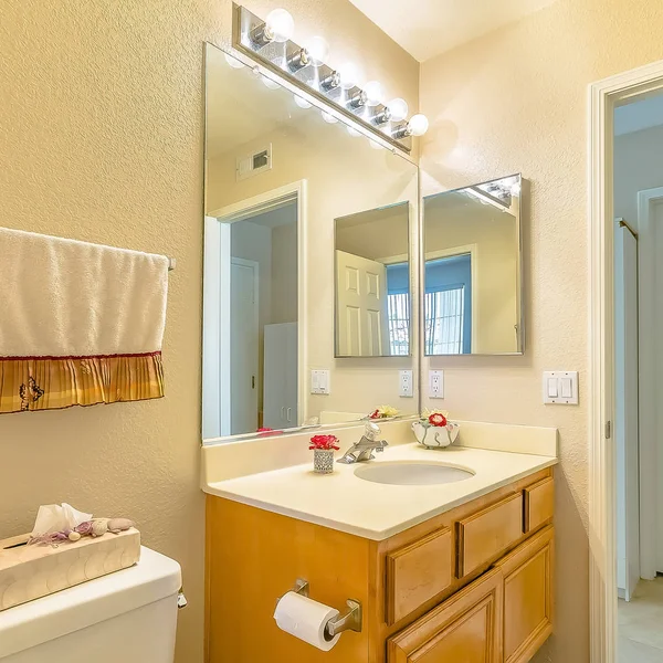 Cadre carré Vanité et toilettes à l'intérieur de la salle de bain d'une maison avec plancher brun — Photo