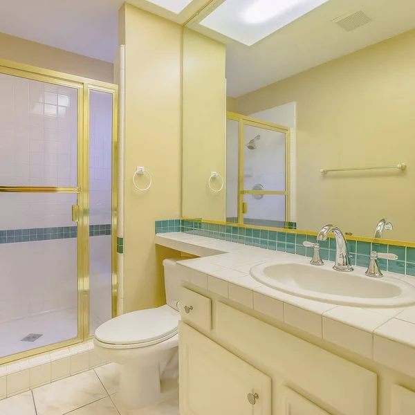 Квадратний інтер'єр ванної кімнати будинку з зеленими і золотими акцентами — стокове фото