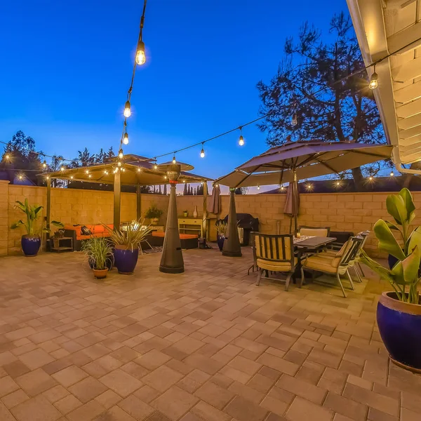 Square frame Patio dining and seating area inside the stone fence and wooden gate of a home