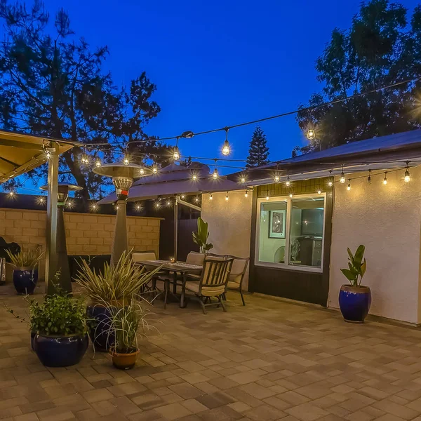 Bir şemsiye altında bir çardak ve yemek alanı altında oturma alanı ile ev Kare çerçeve Veranda