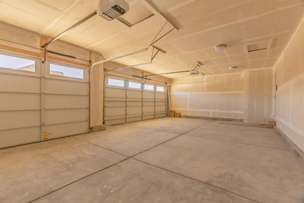 Invändigt i ett tomt garage med två stora dörrar och små rektangulära fönster — Stockfoto
