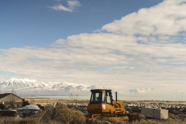 Göl ve kar dağ tepesinde manzaralı bir tepeüzerinde Boş sarı yükleyici