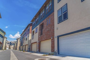 Güneşli bir günde mavi gökyüzü altında çok katlı evlerin ortasında Yol