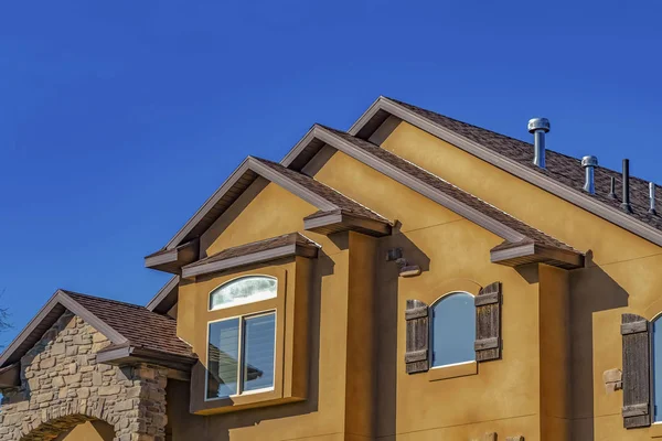 Casa con hormigón y piedra pared exterior contra el cielo azul claro en un día soleado — Foto de Stock