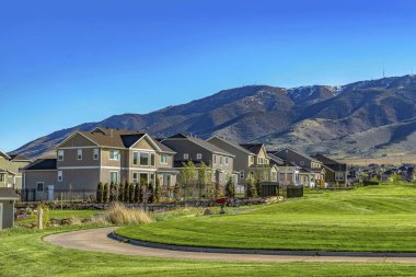 Yemyeşil otlarla kaplı bir vadide kıvrımlı patika ve evler