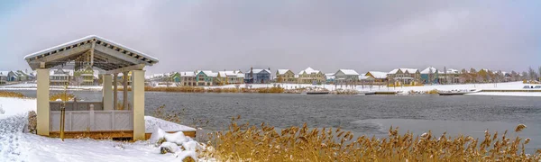 Paviljong på snötäckta stranden av en sjö som ses på en molnig vinterdag — Stockfoto