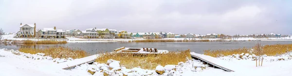 Lago rodeado de nieve cubierta de tierra y bajo el cielo nublado en invierno — Foto de Stock