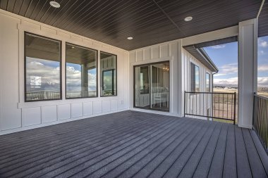 Beyaz duvar ve kahverengi tavan üzerinde yuvarlak ışıklar ile evin geniş balkon