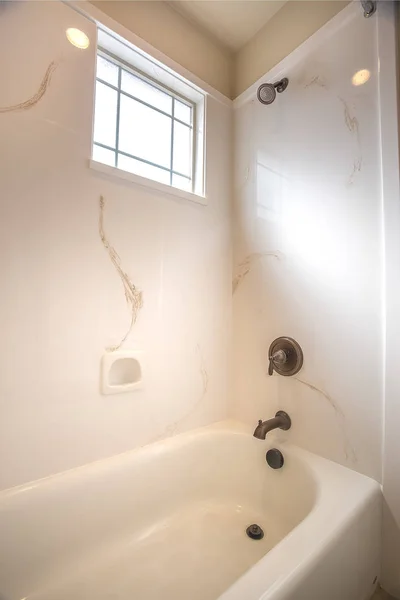 Lśniąca wanna i prysznic wewnątrz łazienki domu z białą ścianą — Zdjęcie stockowe