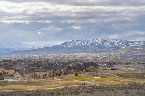 Impresionante montaña nevada que se eleva sobre las casas construidas en el vasto valle — Foto de Stock