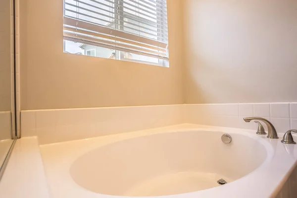 Primer plano de una bañera ovalada blanca con grifo de acero inoxidable dentro de un baño — Foto de Stock