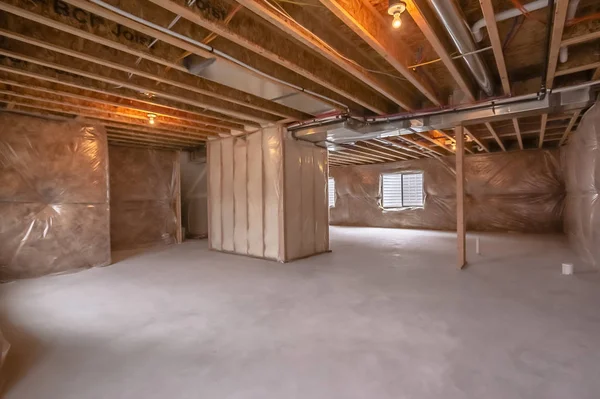 Maison en construction avec poutres de cadre intérieur et mur recouvert de plastique — Photo