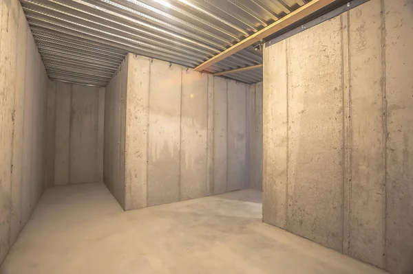 Interior de un edificio vacío con muro de hormigón y techo de metal corrugado — Foto de Stock