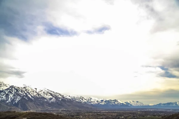 Ciel bleu rempli de nuages brillants et épais sur une montagne imposante et une vaste vallée — Photo