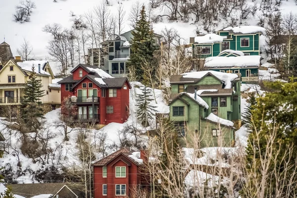 Paisaje de invierno escénico con casas coloridas construidas en la ladera nevada de la montaña — Foto de Stock