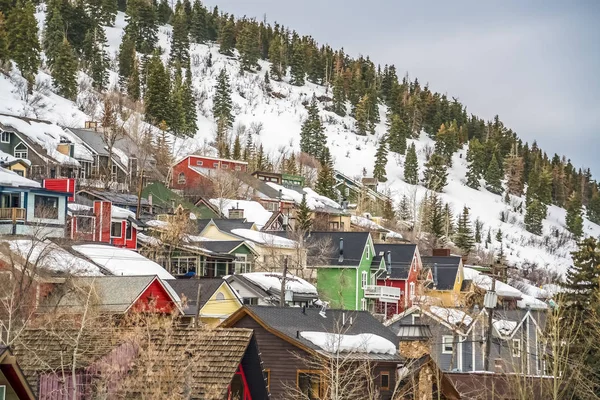 Casas con paredes coloridas construidas en una montaña cubierta de nieve en invierno — Foto de Stock
