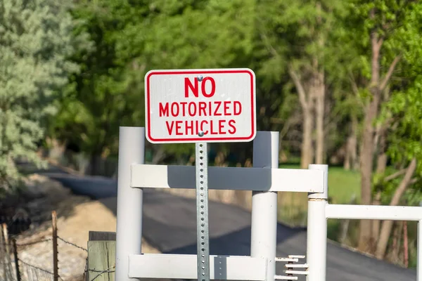 Nahaufnahme eines nicht motorisierten Verkehrsschildes gegen eine Straße mit weißem Tor — Stockfoto