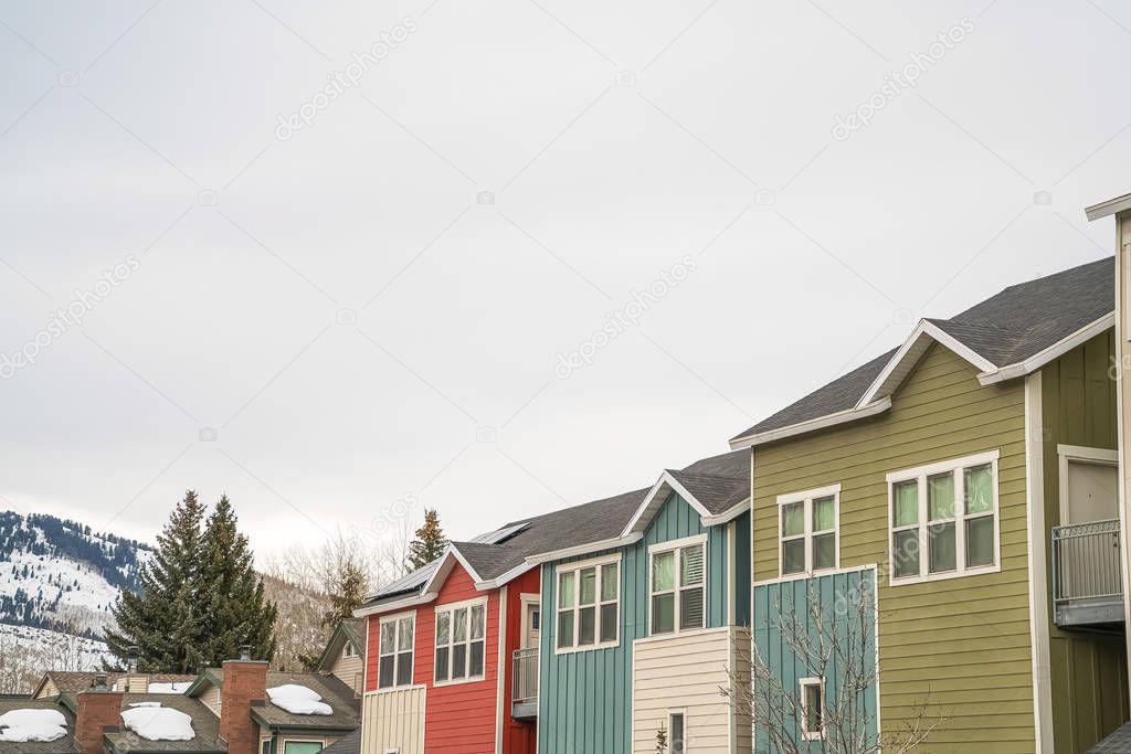 Exterior view of homes with small balconies and multi color sidings on the wall