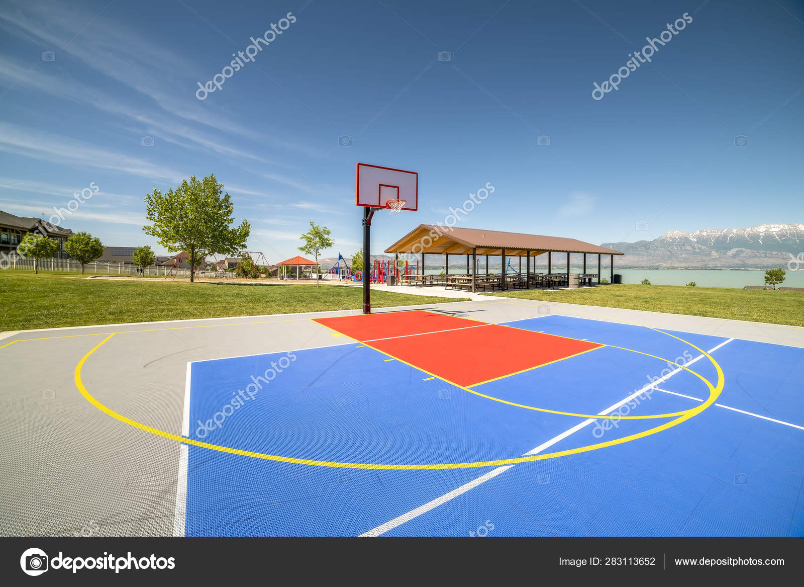 Outdoor basketball court with a picnic pavilion and playground in the  background Stock Photo by 283113652