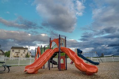 Bir çit ve evler karşı slaytlar salıncak masa ve koltuk ile Oyun Alanı