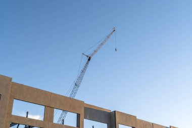 Mavi gökyüzü arka plan ile bitmemiş bina dış ve inşaat vinç