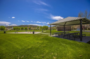 Piknik pavyonu ve güneşli bir günde mavi gökyüzü altında çimenli bir fieild üzerinde su parkı