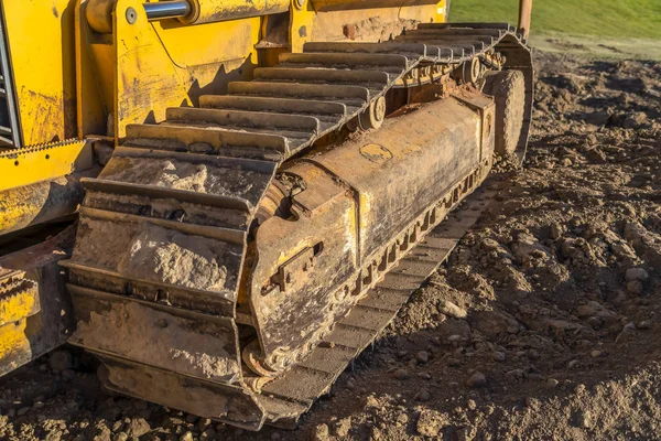 Schmutzige Metallkissen einer gelben Baumaschine an einem sonnigen Tag. — Stockfoto