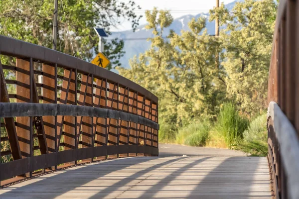 Primer plano de un puente con barandilla metálica y cubierta de madera en un día soleado — Foto de Stock