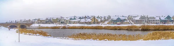 Lago con orillas cubiertas de hierba y nieve en un día nublado de invierno — Foto de Stock