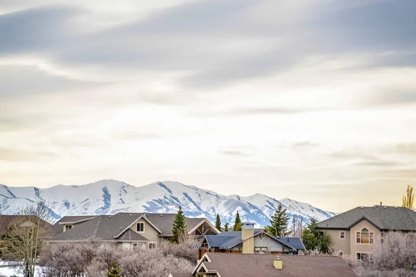 Barrio en invierno con montaña cubierta de nieve y fondo cielo nublado — Foto de Stock