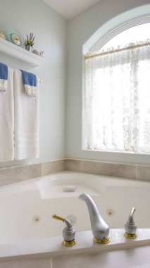 Perde ile kemerli bir pencere yanında altın ve gümüş musluk ile Dikey çerçeve Küvet