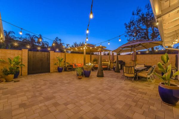 Патио столовая и гостиный уголок внутри каменного забора и деревянные ворота дома
