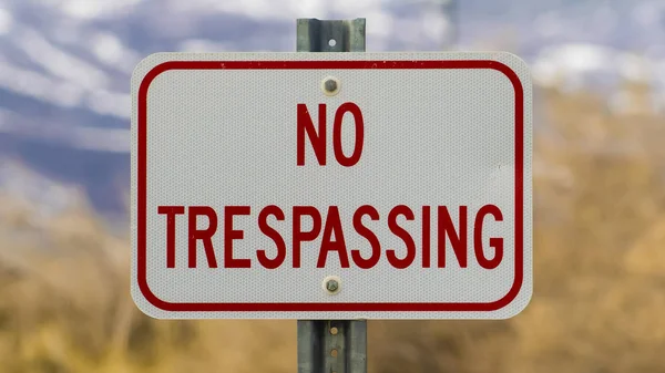 Panorama frame Close up of white sign board with the words No Trespasing painted in red color — Stock Photo, Image