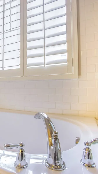 Ramka pionowa Gleaming wbudowany w wannę i okno z żaluzjami wewnątrz łazienki — Zdjęcie stockowe