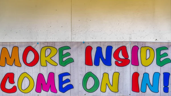 Panorama Sign at the entrance of a building that reads More Inside Come On In