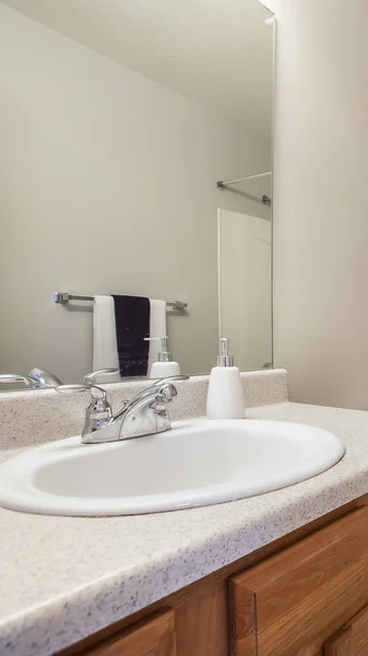 Vertical Pequeño baño interior con una unidad de tocador y toliet contra la pared blanca — Foto de Stock