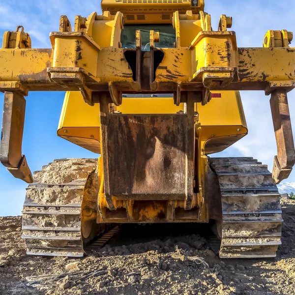 Vehículo de construcción de servicio pesado cuadrado con pintura amarilla pelada y pistas de metal sucio —  Fotos de Stock