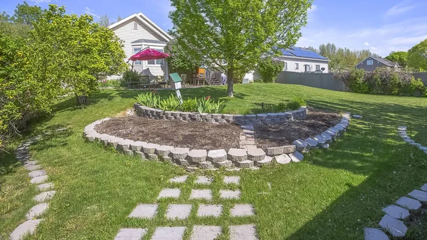 Panorama frame Landscaped grassy yard of home with lush trees and decorative concrete stones