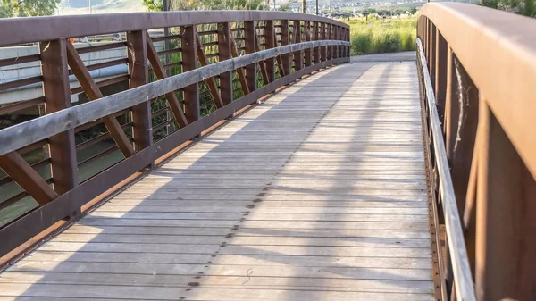 Primer plano de un puente con cubierta de madera y barandilla de celosía marrón en un día soleado —  Fotos de Stock