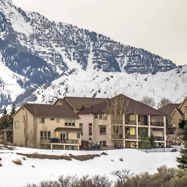 Quartier carré construit sur une colline surplombant une montagne enneigée en hiver — Photo