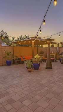 Dize ışıkları ile aydınlatılmış bir taş tuğla veranda üzerinde Dikey Yemek ve oturma alanı