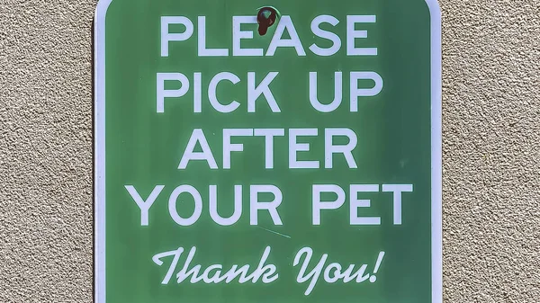 Panorama frame Sign that reads Please Pick Up After Your Pet against a concrete wall surface — Stock Photo, Image