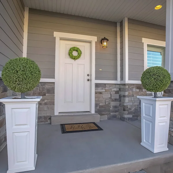 Square Home with wreath on the door and a combination of wood and stone brick wall