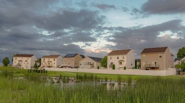 Balkonlu Panorama Homes ve çimenli gölet köprüsü ve geniş yeşil alan manzarası